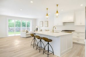 Bright kitchen and living space with white oak Wickham hardwood flooring and white shaker cabinets