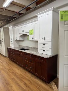 Full view of Marsh Summerfield kitchen cabinet display featuring white upper cabinets, stained maple lower cabinets, and Nevasca Mist granite countertop