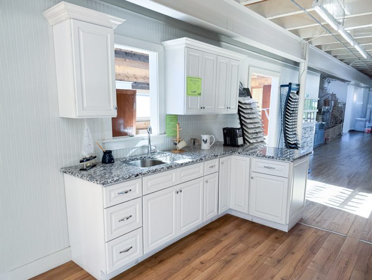 Newport White raised-panel kitchen cabinet display with Gran Perla granite countertop and crown moulding
