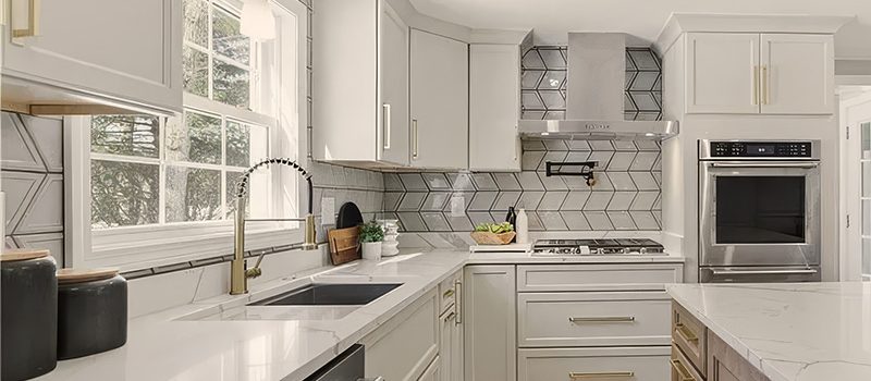 Marsh Savannah white kitchen cabinets with Sonona Sand island cabinets, quartz countertops and modern kitchen design