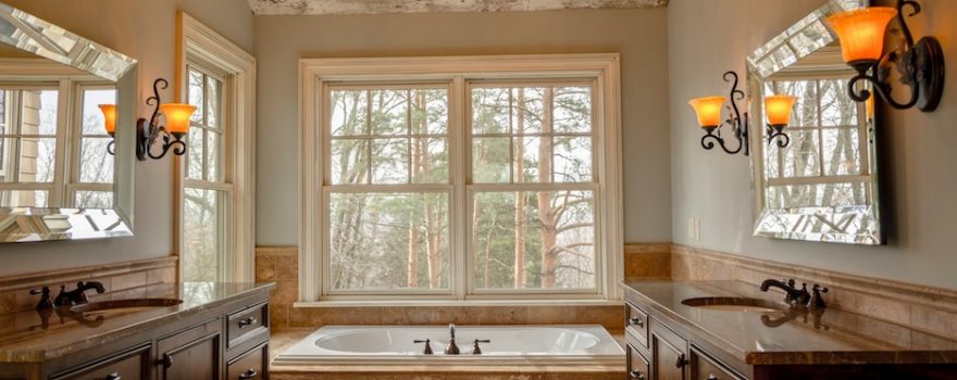 Farmhouse bathroom vanity ideas that feel warm and current &mdash; wood tops, shaker doors, classic hardware, and styling that aren't costumey.